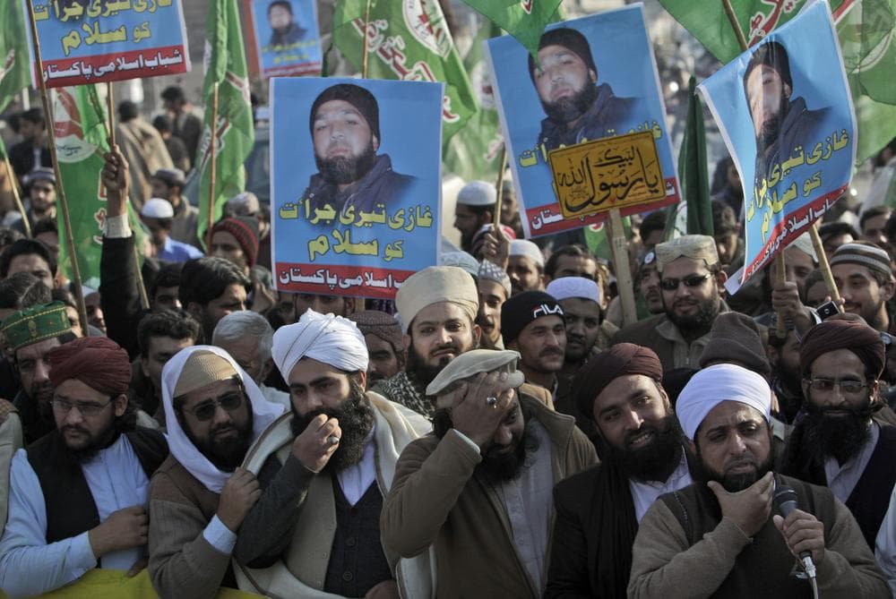Supporters of Pakistani religious party Sunni Tehreek raise posters showing Mumtaz Qadri, alleged killer of Punjab governor Salman Taseer, during a rally supporting him and calling his release in Rawalpindi, Pakistan. (AP)
