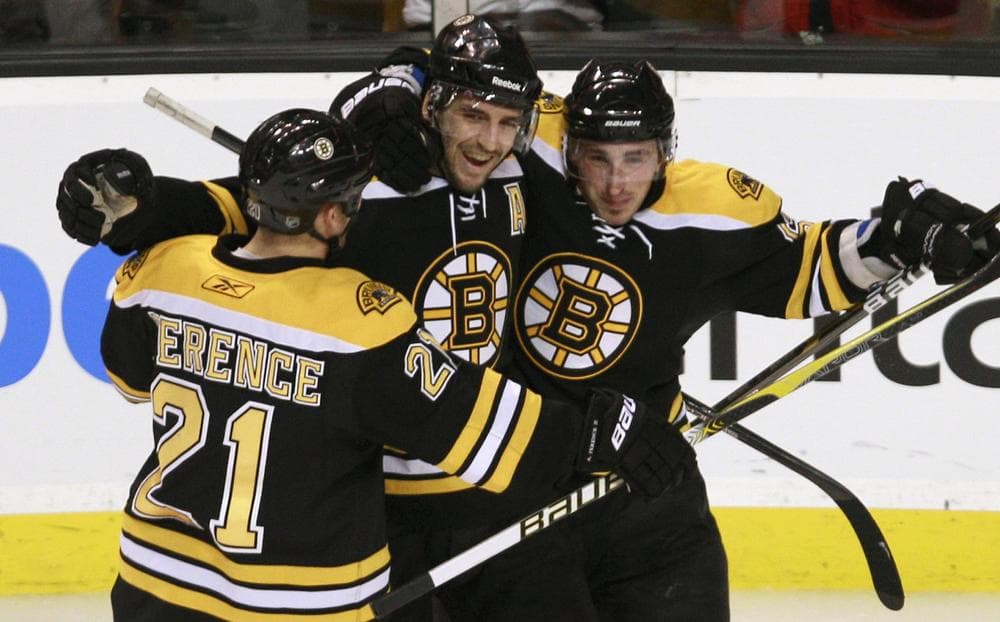 Boston center Patrice Bergeron, center, is congratulated by teammates Andrew Ference, left, and Brad Marchand, right, after scoring the third goal of his hat trick against Ottawa during the third period of an NHL hockey game in Boston on Tuesday. (AP)