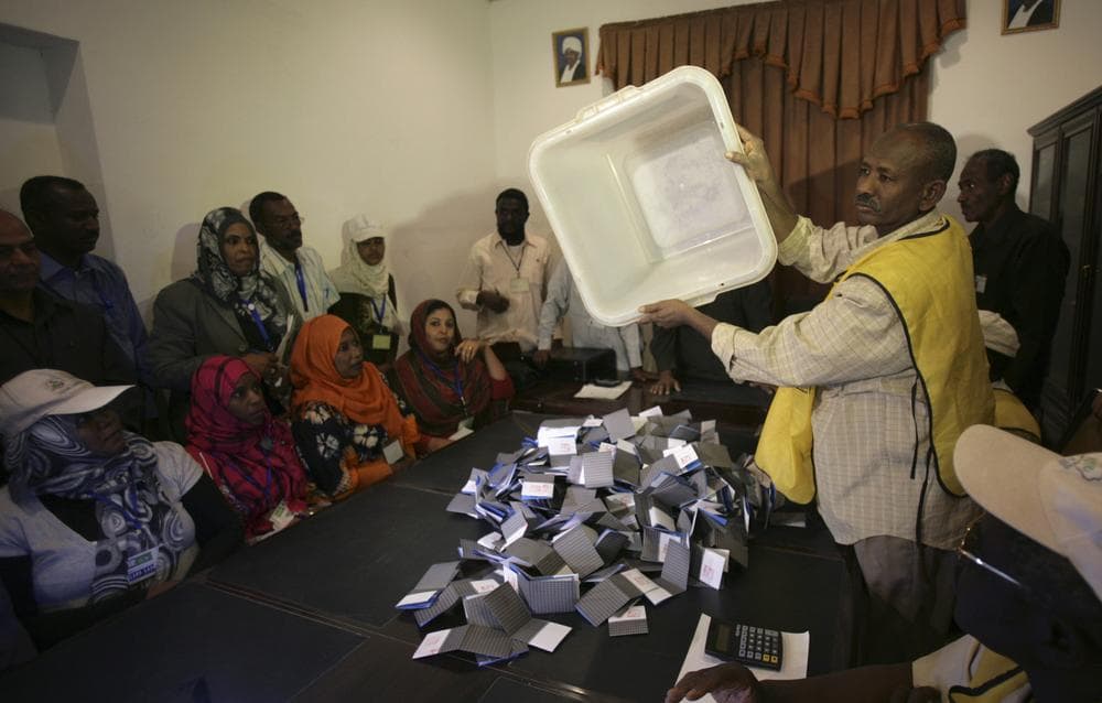 A polling staff member empties a ballot box at the end of a weeklong voting process, at a polling center in Khartoum, Sudan. (AP)