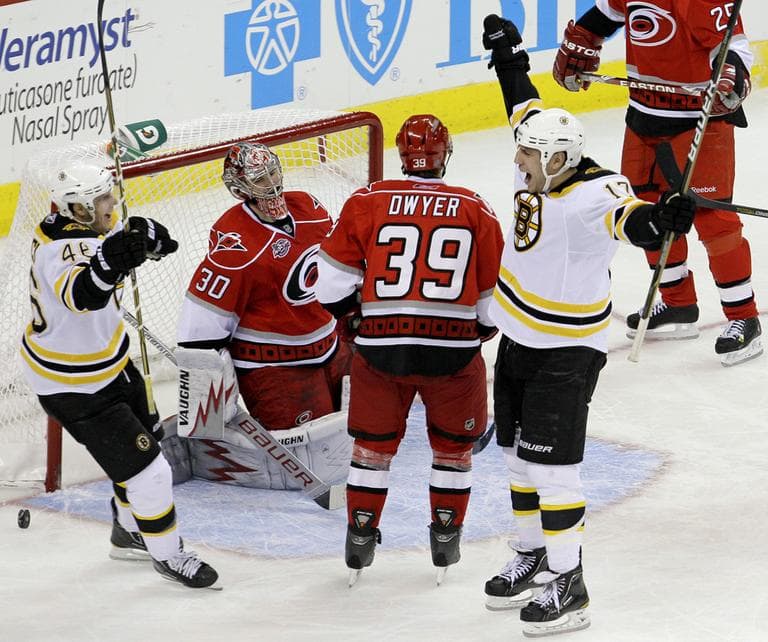Boston's Milan Lucic (17) and David Krejci, left, of the Czech Republic, celebrate Lucic's goal against Carolina goalie Cam Ward (30) as Patrick Dwyer (39) looks on during the third period of the game in Raleigh, N.C., on Tuesday. Boston won 3-2. (AP)