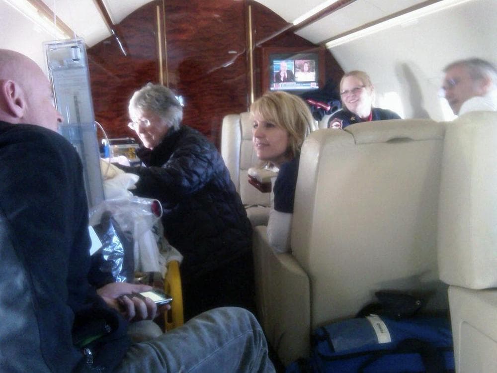 In this Friday, Jan. 21, 2011 photo released by the office of Rep. Gabrielle Giffords, D-Ariz., Gloria Giffords, the congresswoman's mother, center, talks with her daughter aboard the plane transporting her from Tucson to Houston. The congresswoman's husband, Capt. Mark Kelly, far left. talks with  Tracy Culbert, one of Congresswoman Giffords' nurses in UMC's intensive care unit. (AP Photo/Congresswoman Giffords' Office)