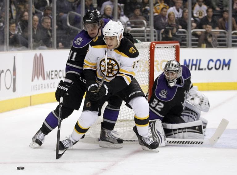 Los Angeles center Anze Kopitar, left, reaches for the puck next to Boston left wing Milan Lucic, as Kings goalie Jonathan Quick looks on during the first period of the game in Los Angeles on Monday. (AP)