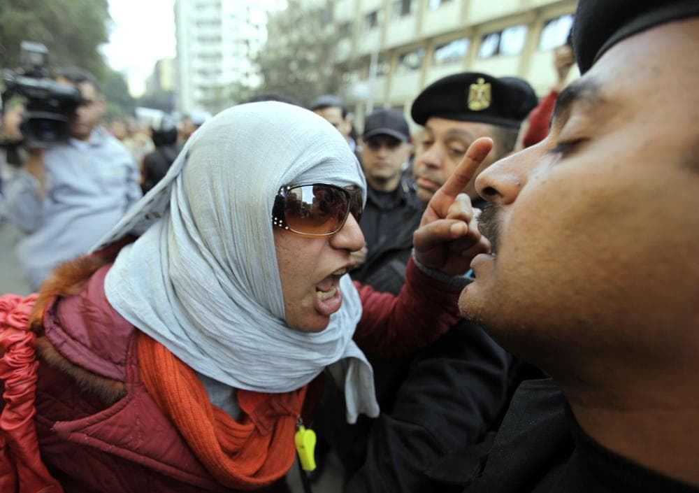 An Egyptian activist shouts at anti-riot policemen who block the way leading to journalists syndicate in downtown Cairo, Egypt. (AP)