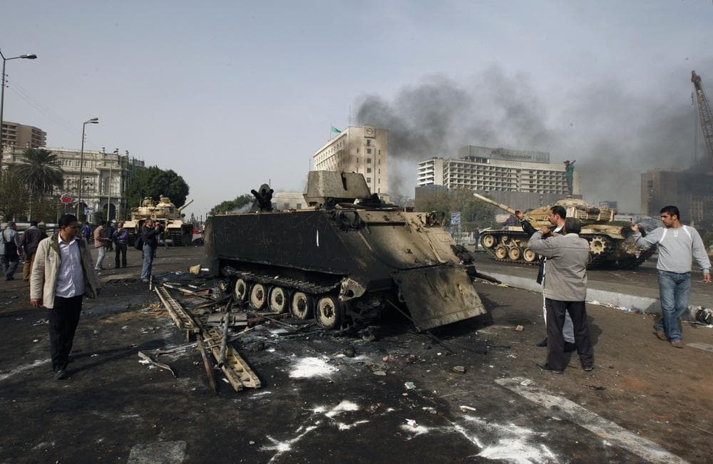 Egyptians photograph a burned out army armored personnel carrier in downtown Cairo, Egypt, Saturday, Jan. 29, 2011. (AP Photo/Khalil Hamra)