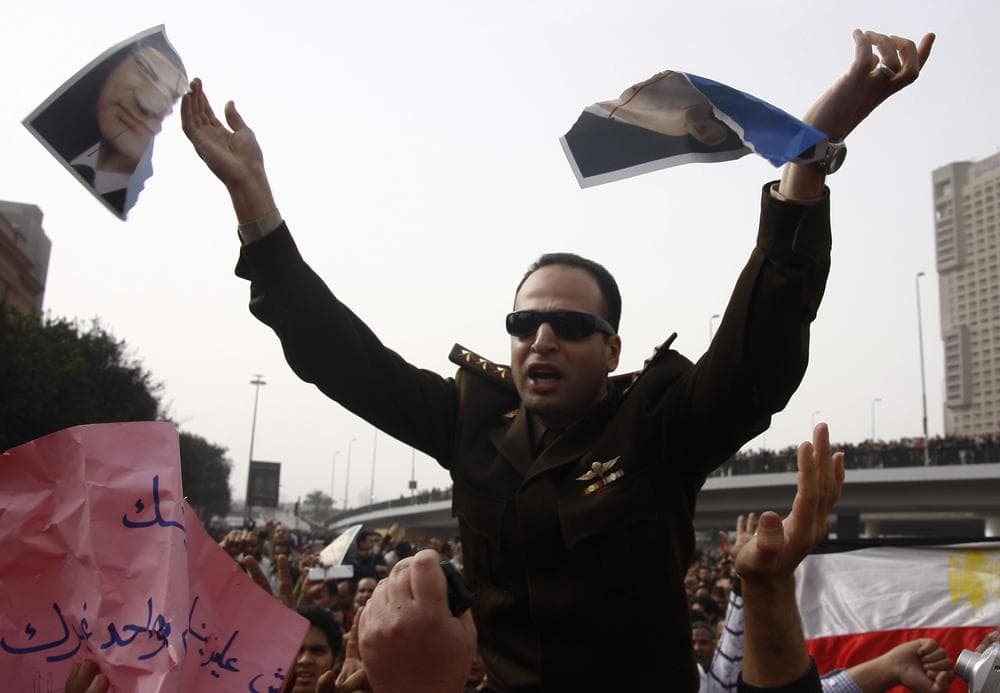 An army officer who joined anti-government protester tears up a picture of Egyptian President Hosni Mubarak, downtown Cairo, Egypt, Saturday, Jan. 29, 2011. (AP Photo/Ahmed Gumaa)