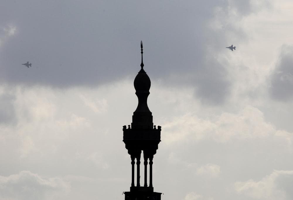 Military fighter jets are seen behind the minaret of the Aguza mosque in Cairo, Sunday, Jan. 30, 2011. (AP Photo/Manoocher Deghati)