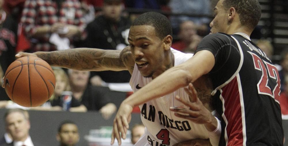 San Diego State&#039;s Malcolm Thomas lowers his shoulder into UNLV&#039;s Chace Stanback. (AP Photo/Lenny Ignelzi)