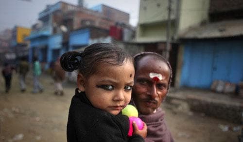 A young Indian girl looks on with her father, in their village, Kosi, some 180 kilometers from Patna, India, Jan. 24, 2011. (AP)