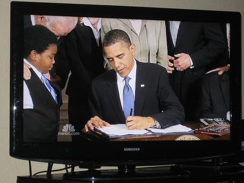 President Obama signing the health care bill into law