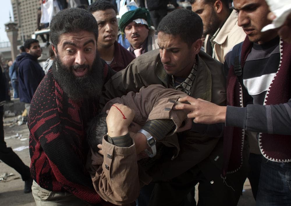 An anti-government protestor gets assistance after being wounded during clashes in Cairo, Egypt, Thursday. (AP)