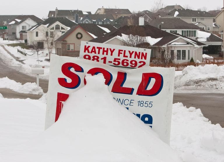 A sold sign, partially covered in snow (AP)