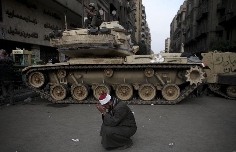 An Egyptian Muslim cleric weeps for slain protesters in front of on army tank in Tahrir square, in Cairo, Wednesday. (AP)