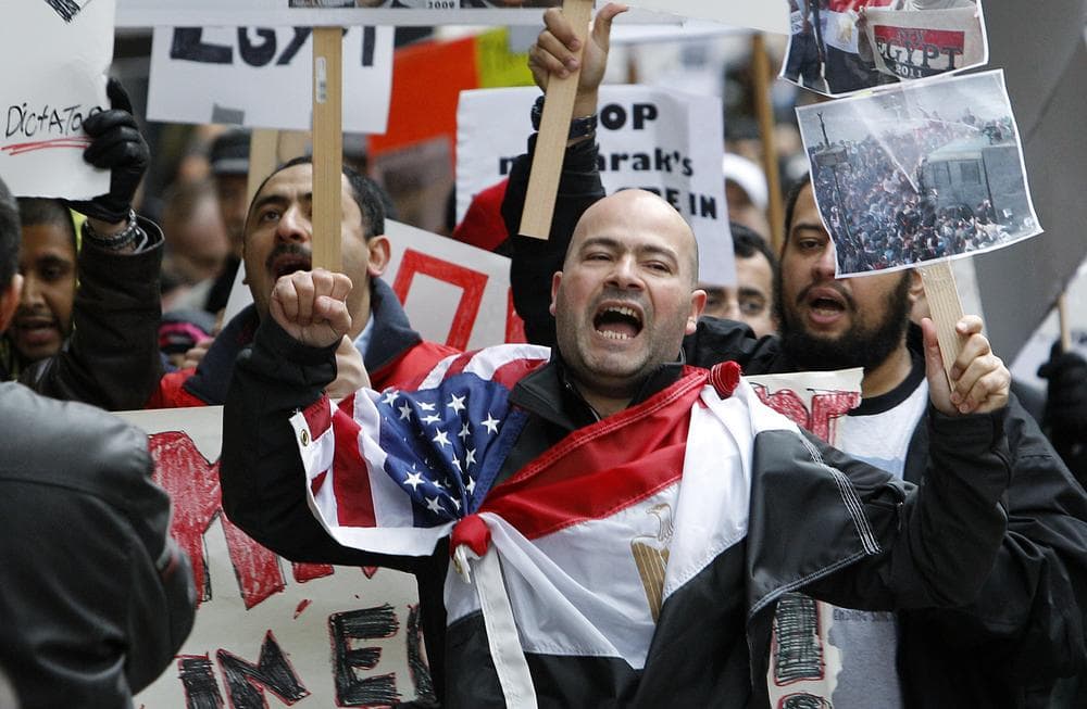 Alex Elwardi, a naturalized U.S. citizen from Egypt, wears U.S. and Egyptian flags across his shoulders as he chants during a demonstration in support of ousting Egyptian President Hosni Mubarak, Saturday, Feb. 5, 2011, in Seattle. Several hundred people protested for nearly two hours, calling for solidarity with demonstrators in Egypt and a change in the regime there. (AP Photo/Elaine Thompson)