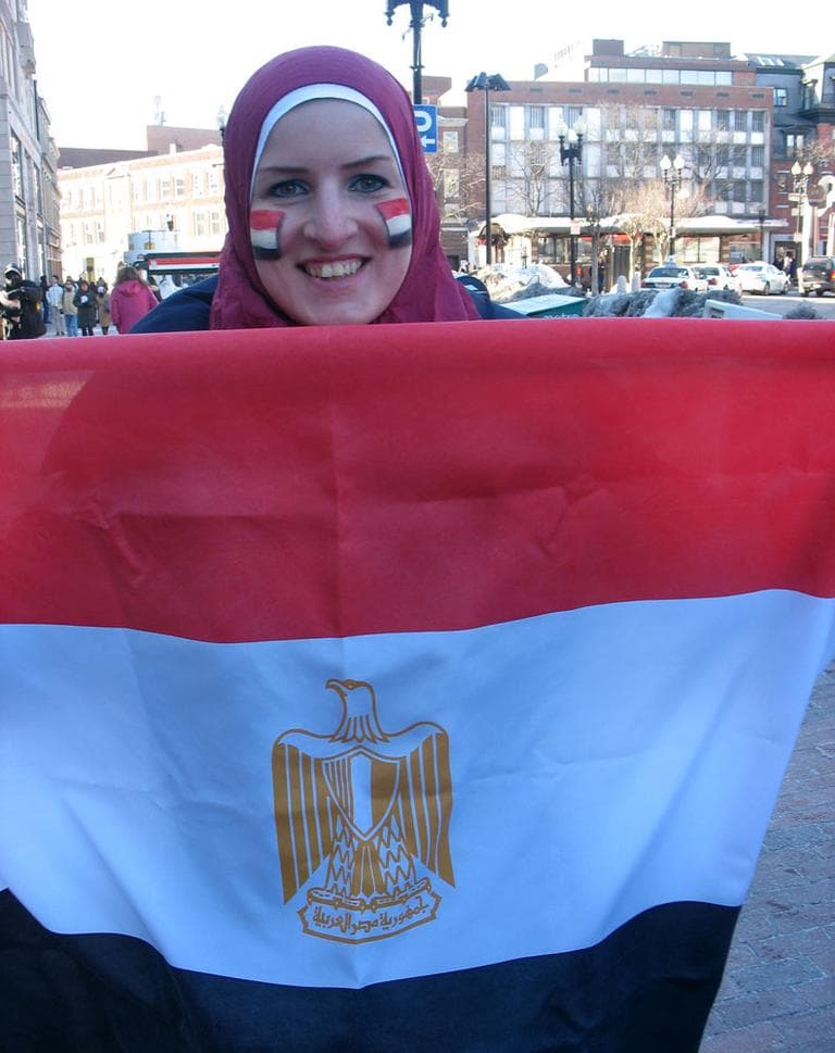 Mariam Mahmoud holds the Egyptian flag Friday in Harvard Square, where about two dozen Egyptians gathered for a spontaneous celebration. (Monica Brady-Myerov/WBUR)