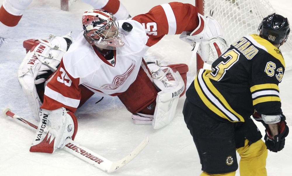 Detroit Red Wings goalie Jimmy Howard, left, makes a save on a shot by Boston Bruins center Brad Marchand during the third period in Boston on Friday. (AP)