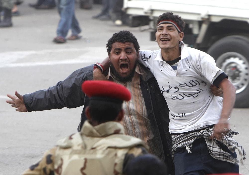 Egyptian protesters react as they are released after their arrest by army when they resisted their removal from Tahrir Square in downtown Cairo, Egypt, Sunday, Feb. 13, 2011.  (AP Photo/Hussein Malla)