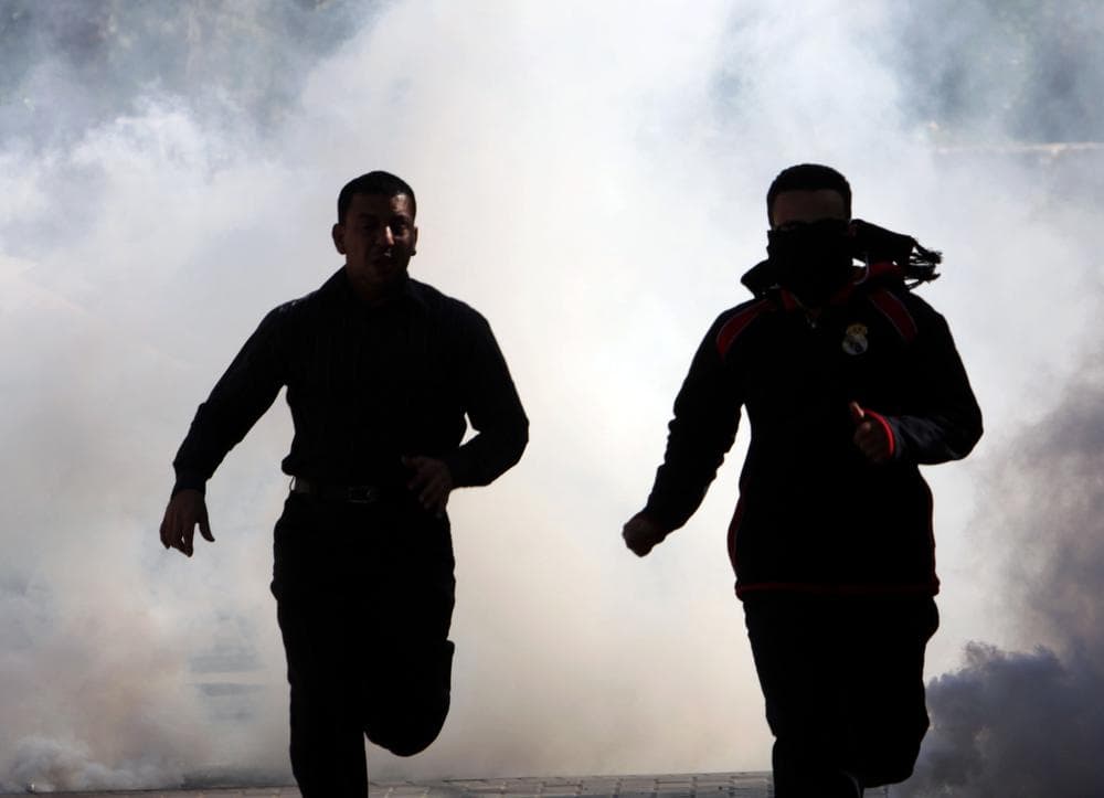 Bahraini demonstrators run from tear gas Monday, Feb. 14, 2011, as riot police disperse a protest in the village of Duraz, Bahrain, outside the capital of Manama. (AP)