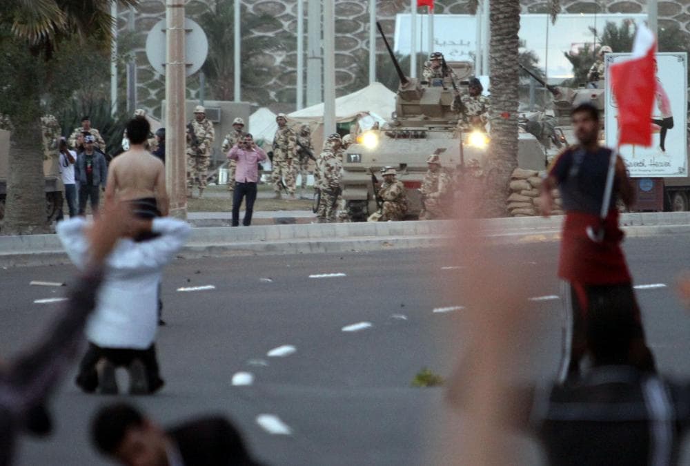 Bahraini protesters face off against army vehicles after some shots were fired near the Pearl roundabout Friday, Feb. 18, 2011, in Manama, Bahrain.  Several began to pray and shouted &quot;peaceful, peaceful&quot; until riot police fired tear gas. (AP)