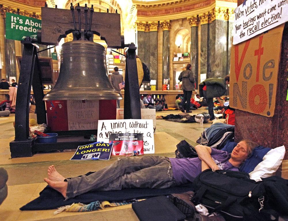 Protesters sleep inside the state Capitol Tuesday, Feb. 22, 2011, in Madison, Wis. Opponents to Governor Scott Walker's bill to eliminate collective bargaining rights for many state workers are taking part in their eighth day of protesting.  (AP)