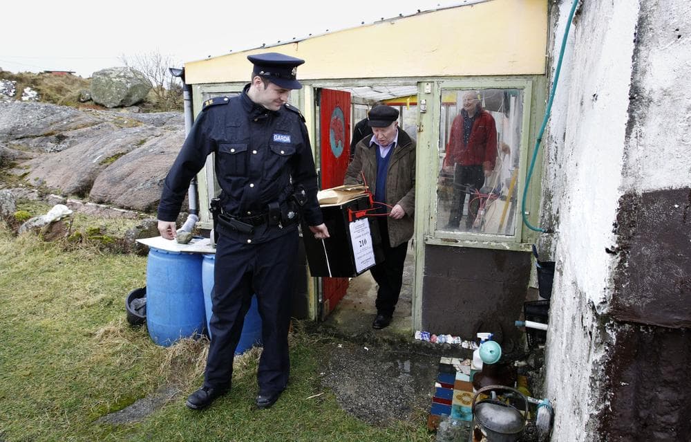 Irish Police officer Ronan McNamara, right,  and Hugh O' Donald Presiding Officer leave the polling station with the ballot box after voting on Inishfree Island off the coast of Donegal, Ireland, Wednesday, Feb. 23, 2011.  Islanders around Ireland voted Wednesday in the General Election with the Irish mainland due to vote on Friday.  (AP)