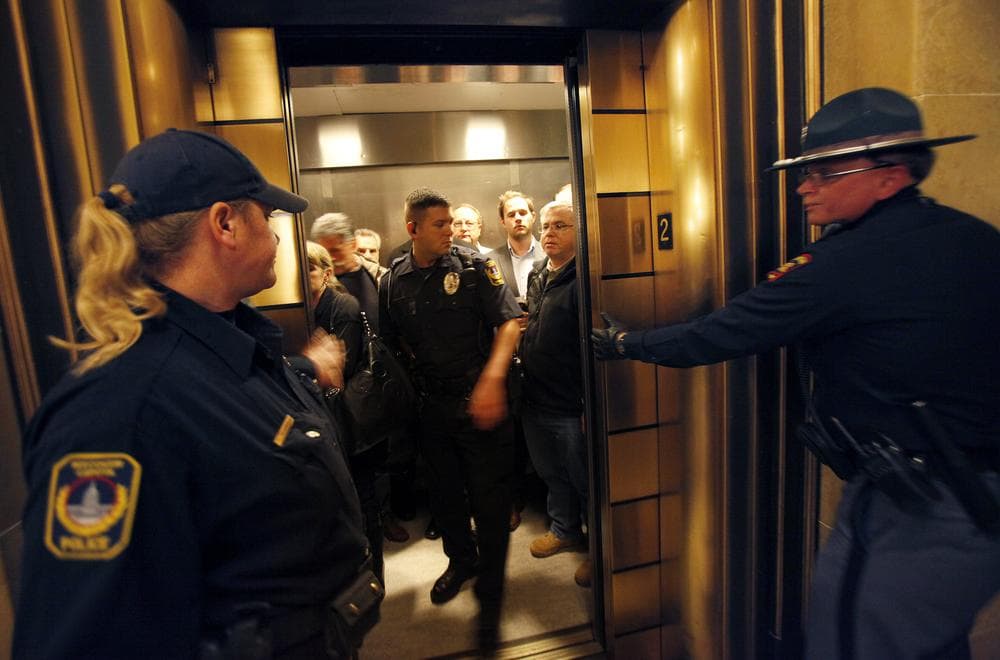 Escorted by law enforcement officers, Assembly Republicans exit the state Capitol after cutting off debate and rapidly voting to pass a controversial budget repair bill in the state Assembly in Madison, Wis. (AP)