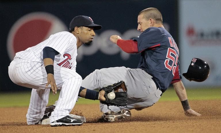 Boston Red Sox player Ryan Kalish safely slides under the tag of Minnesota Twins shortstop Alexi Casilla in the fifth inning of their Grapefruit League spring training season opening baseball game in Fort Myers, Fla. on Sunday. (AP)