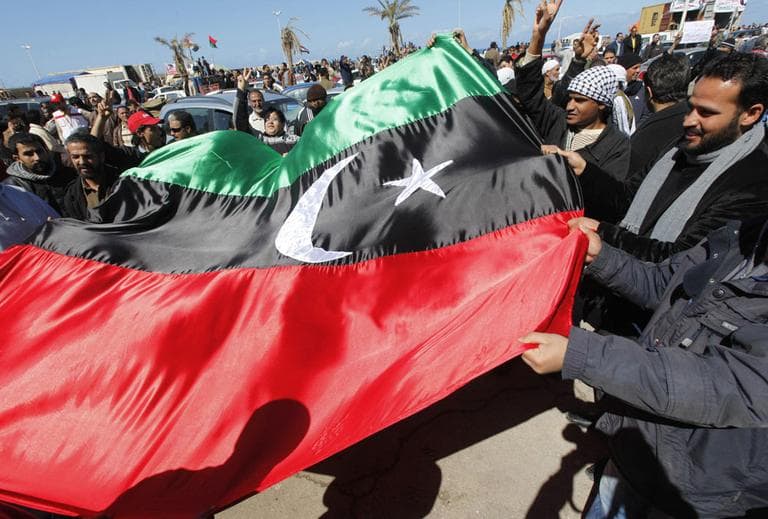 Anti-Libyan leader Moammar Gadhafi protesters wave the old Libyan flag as they celebrate the freedom of the Libyan city of Benghazi, Libya, on Monday. (AP)