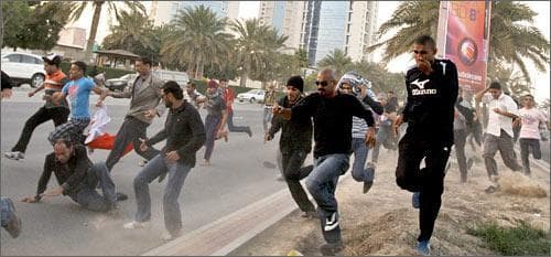 Bahraini anti-government demonstrators run during clashes between protesters and the Bahraini army. (AP)