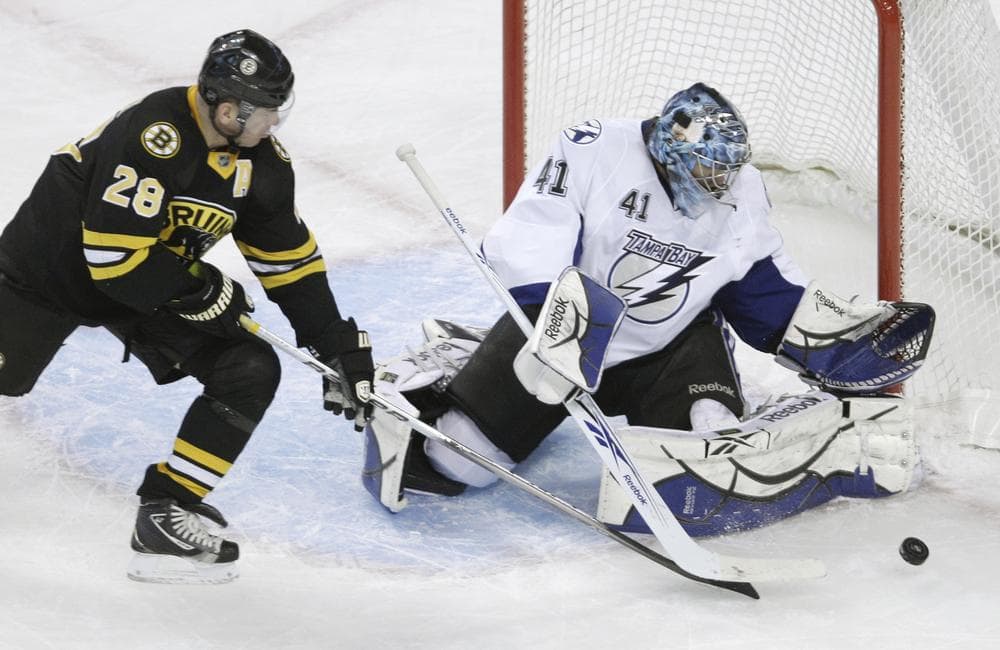 Boston Bruins left wing Mark Recchi, left, tries to get his stick on the rebound as Tampa Bay Lightning goalie Mike Smith, right, makes the save during the first period of an NHL hockey game in Boston on Thursday. (AP)