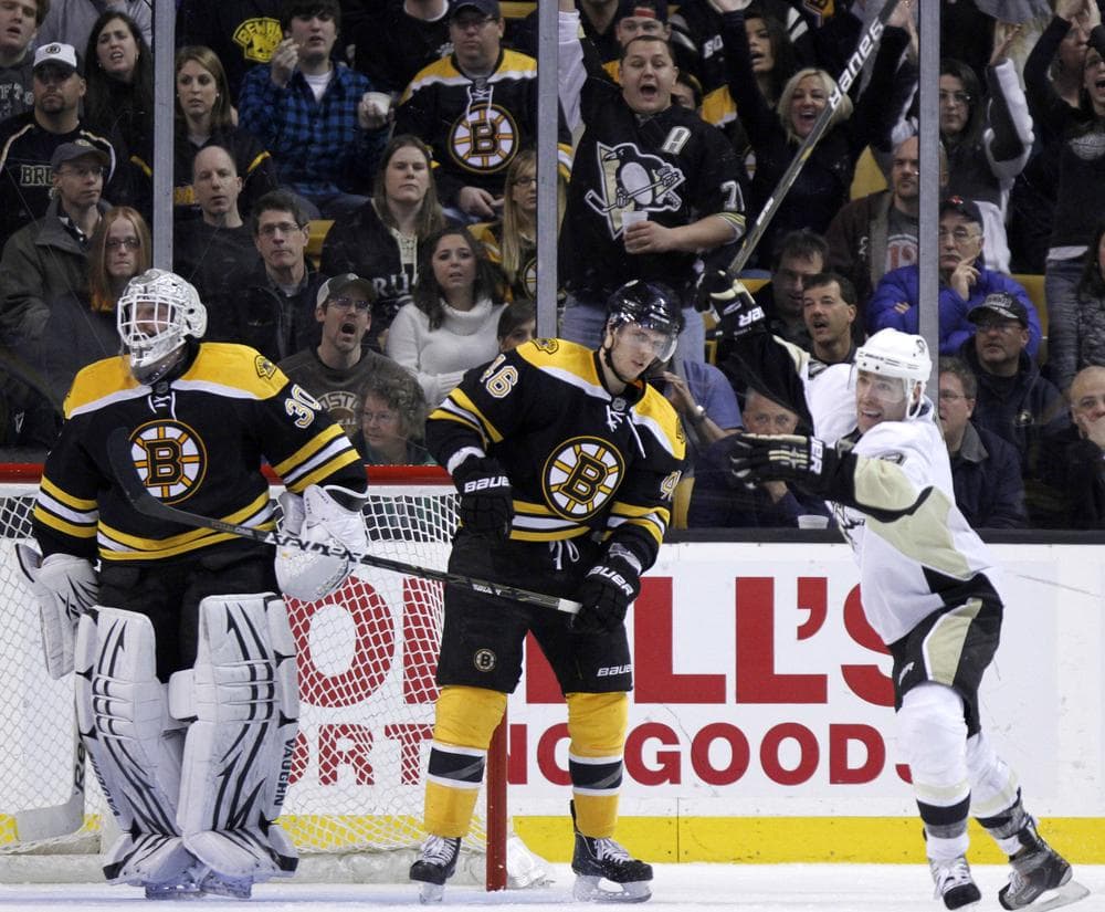 Penguins' Pascal Dupuis, right, celebrates a goal by teammate Dustin Jeffrey as  Bruins' Tim Thomas, left, and David Krejci, center, look on in the second period on Saturday in Boston. (AP)