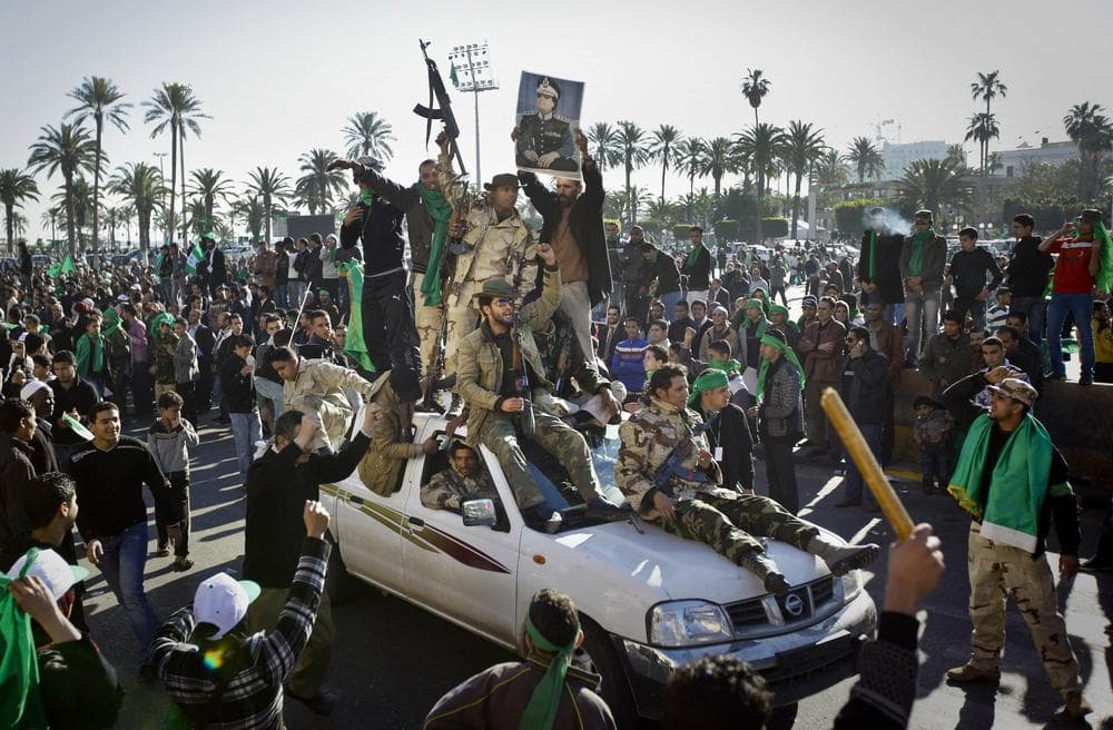 Pro-Gadhafi soldiers and supporters gather in Green Square in Tripoli, Libya Sunday. Thousands of Moammar Gadhafi's supporters poured into the streets of Tripoli on Sunday morning, waving flags and firing their guns in the air in the Libyan leader's main stronghold, claiming overnight military successes. (AP)