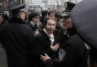 A man, center, confronts with police officers in front of a cinema that was a planned protest site in Shanghai, China. (AP)