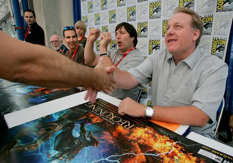 At right, former Red Sox pitcher and 38 Studios founder Curt Schilling shakes hands with a fan at Comic-Con in July 2010 in San Diego. (AP/Electronic Arts)