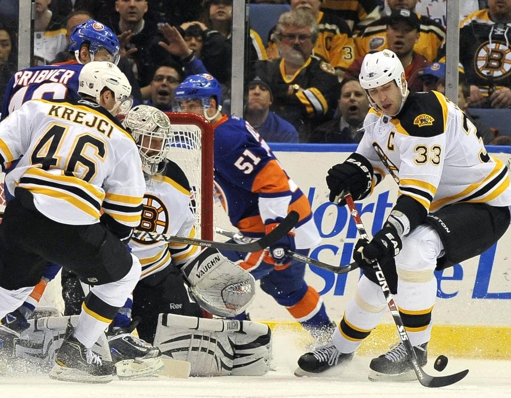 Bruins' Zdeno Chara (33) drives the puck away from New York Islanders' Michael Grabner (40) of Austria and Frans Nielsen (51) of Demark as Bruins'  David Krejci (46) of the Czech Republic and goalie Tim Thomas (30) defend during the third period Friday, March 11, 2011, in Uniondale, N.Y. (AP Photo/Kathy Kmonicek)