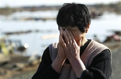 A resident wipes tears as she finds no remains of her home, in Soma city, south of Sendai city. (AP)