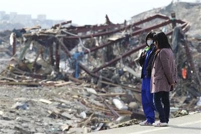 People look at a devastated area of Minamisanriku, northern Japan, days after a powerful earthquake-triggered tsunami hit the country's east coast. (AP/The Yomiuri Shimbun, Tsuyoshi Matsumoto) 