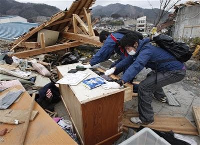 Richi Shida, right, and younger brother Kento try to open their chest of drawers at Ofunato, Iwate Prefecture, northern Japan. (AP)