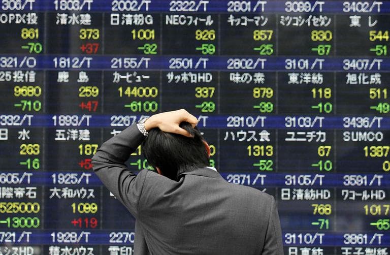 A man reacts as he looks at a stock price board in a street Monday, March in Tokyo, Japan. (AP)