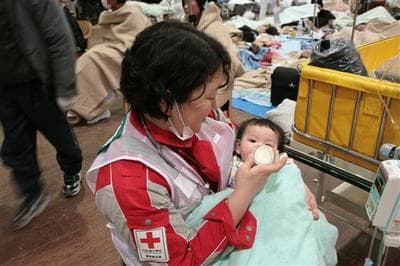 A baby survivor is fed milk by a member of Japanese RC's National Disaster Response Team at the Ishinomaki Red Cross Hospital in Ishinomaki in Miyagi Prefecture. (AP/Japanese Red Cross)