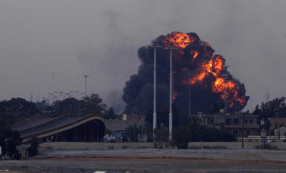 A huge explosion is seen over the outskirts of Benghazi after a plane of Gadafi&#39;s forces was shot down over eastern Libya Saturday. (AP)