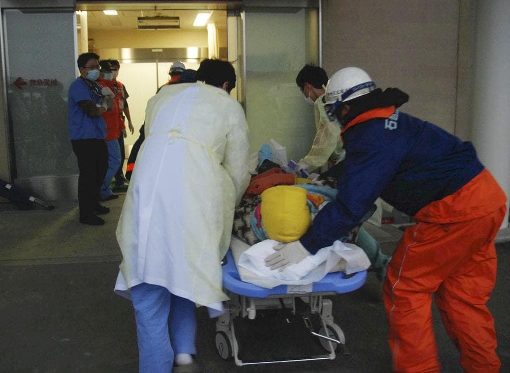 A woman on a stretcher gets carried into the Ishinomaki Red Cross Hospital in Ishinomaki, northern Japan, Sunday, after the March 11 earthquake and tsunami.  (AP Photo/The Yomiuri Shimbun, Masanori Yamashita)