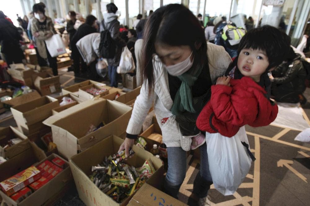 An evacuee mother receives emergency food aid at the evacuation center set up at Saitama Super Arena in Saitama, Japan. (AP/The Yomiuri Shimbun, Jun Yasukawa)