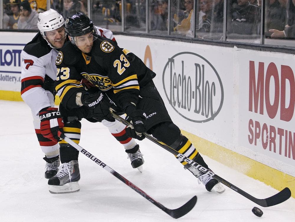 New Jersey Devils defenseman Henrik Tallinder (7) vies for the puck with Boston Bruins center Chris Kelly (23) during the second period of the game in Boston on Tuesday. (AP)