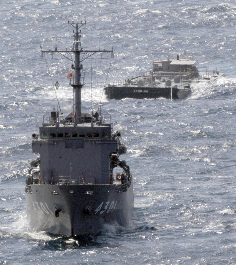 U.S. Navy&#39;s barge YOGN-115, back, is towed by Japan&#39;s Maritime Self-Defense Force&#39;s multi purpose support ship off the coast of Isumi, Japan, Saturday. (AP)