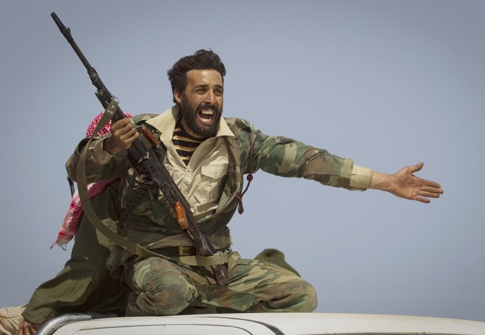 A Libyan rebel urges people to leave, as shelling from Gadhafi's forces started landing on the frontline outside of Bin Jawaad, 150 km east of Sirte, central Libya. (AP)