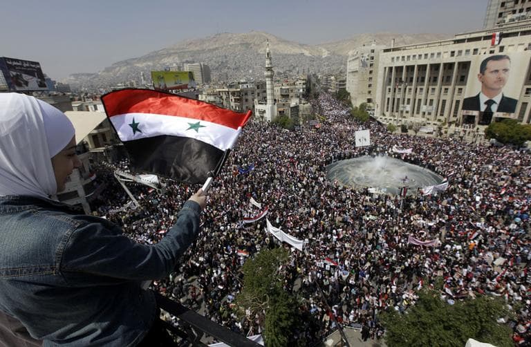Amid the resignation of President Bashar Assad's cabinet, pro-government demonstrators gathered in Damascus, Syria, on Tuesday to show their support for Assad as he faces the biggest challenge to his 11-year rule. (AP)