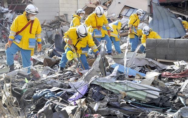 Police officers search for missing persons in the rubble in Kamaishi, northern Japan, on Monday. (AP)