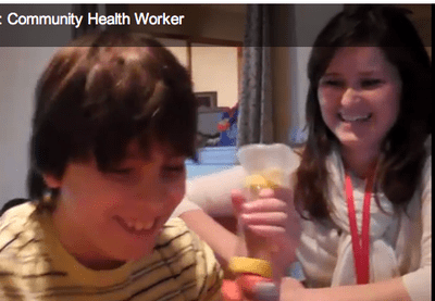 A health worker visits a young boy at home to remind him how to use his asthma medications