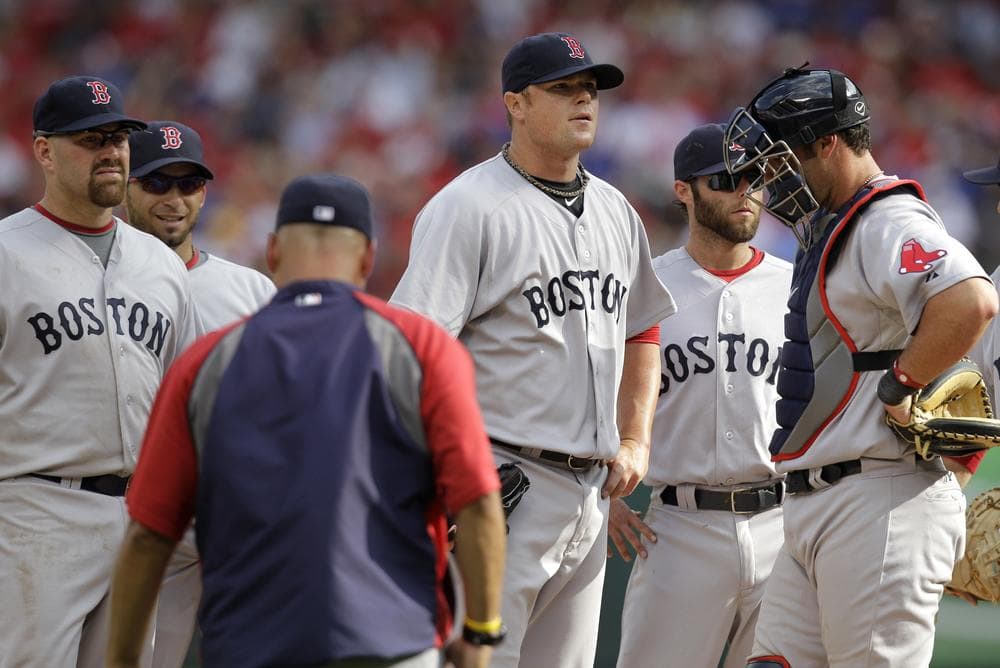 Boston Red Sox's Jon Lester, center, stands surrounded by teammates as he waits to be pulled by manager Terry Francona, left front, in the sixth inning Friday in Texas. (AP)