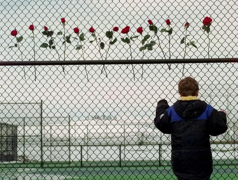 A boy looks past a make-shift memorial to the 13 killed in the Columbine High School massacre at the high school. (AP)